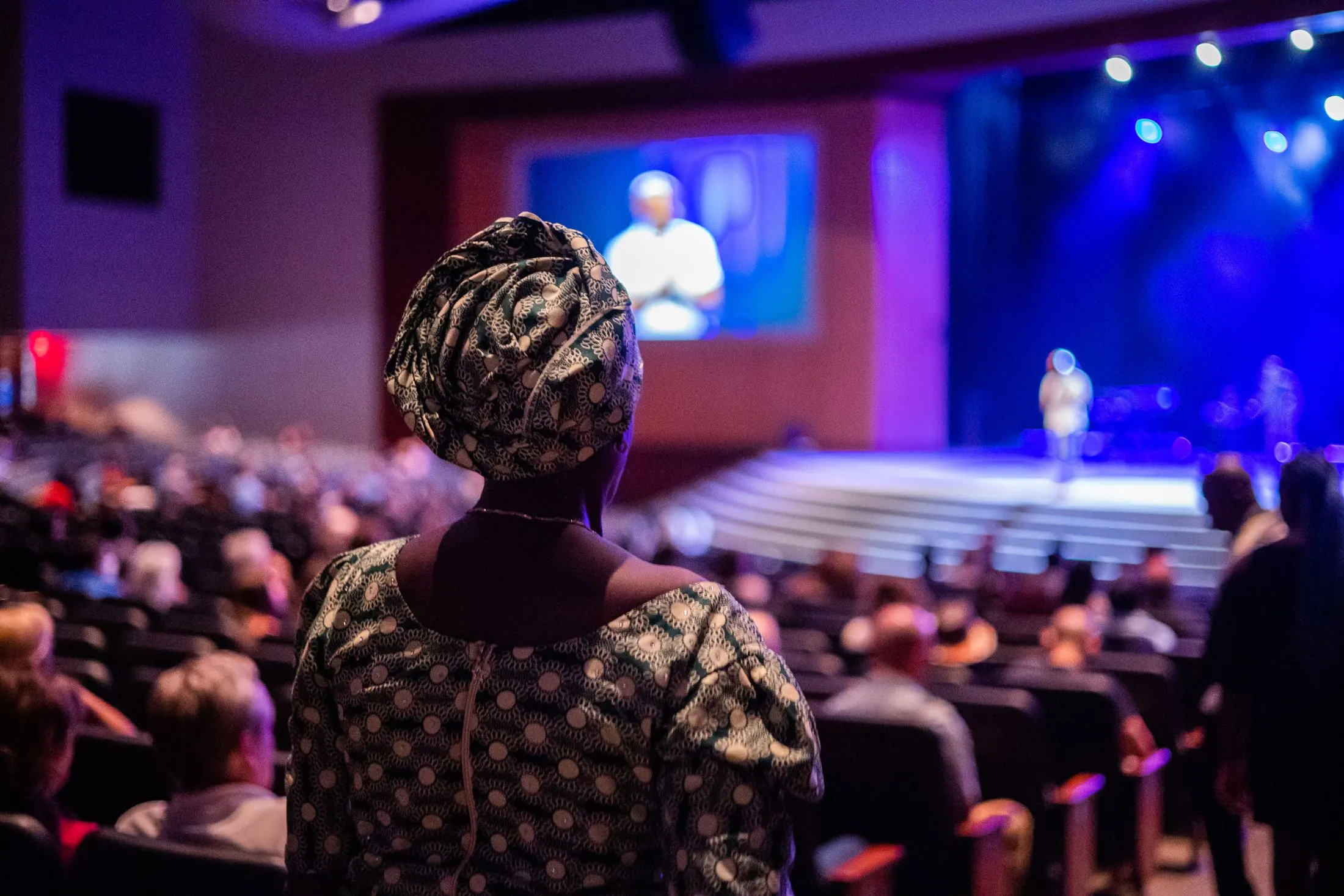Delegates in a packed auditorium watching a speaker on stage