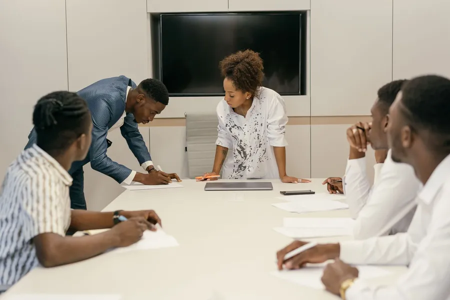 Managers reviewing papers around a conference table